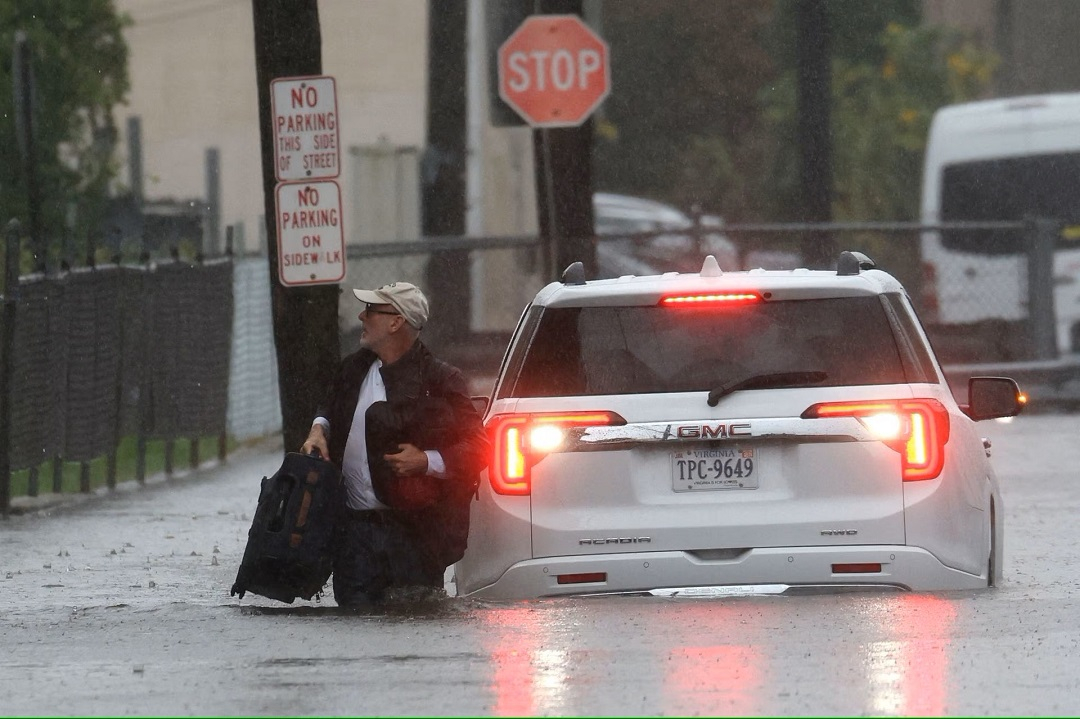 Người đàn ông xách hành lý bỏ lại chiếc ô tô bị chết máy ở Mamaroneck, ngoại ô thành phố New York, hôm 29/9. Ảnh: Reuters.
