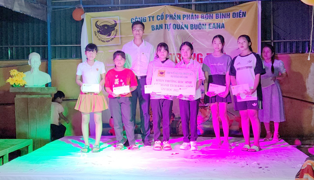 Đại diện Công ty Cổ phần phân bón Bình Điền trao học bổng cho các em nhỏ tại Buôn Ea Na. Ảnh: Quang Yên.