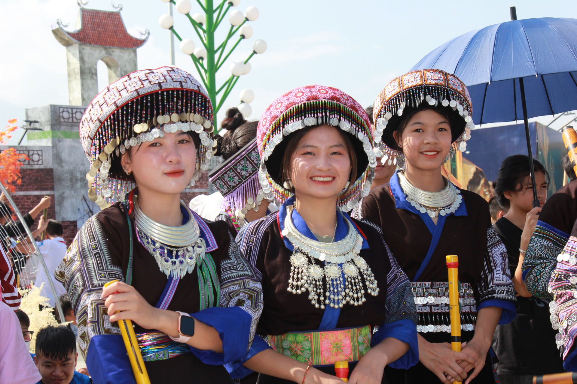 Những cô gái người Mông xúng xính trong bộ trang phục dân tộc truyền thống xuống núi tham gia lễ hội.