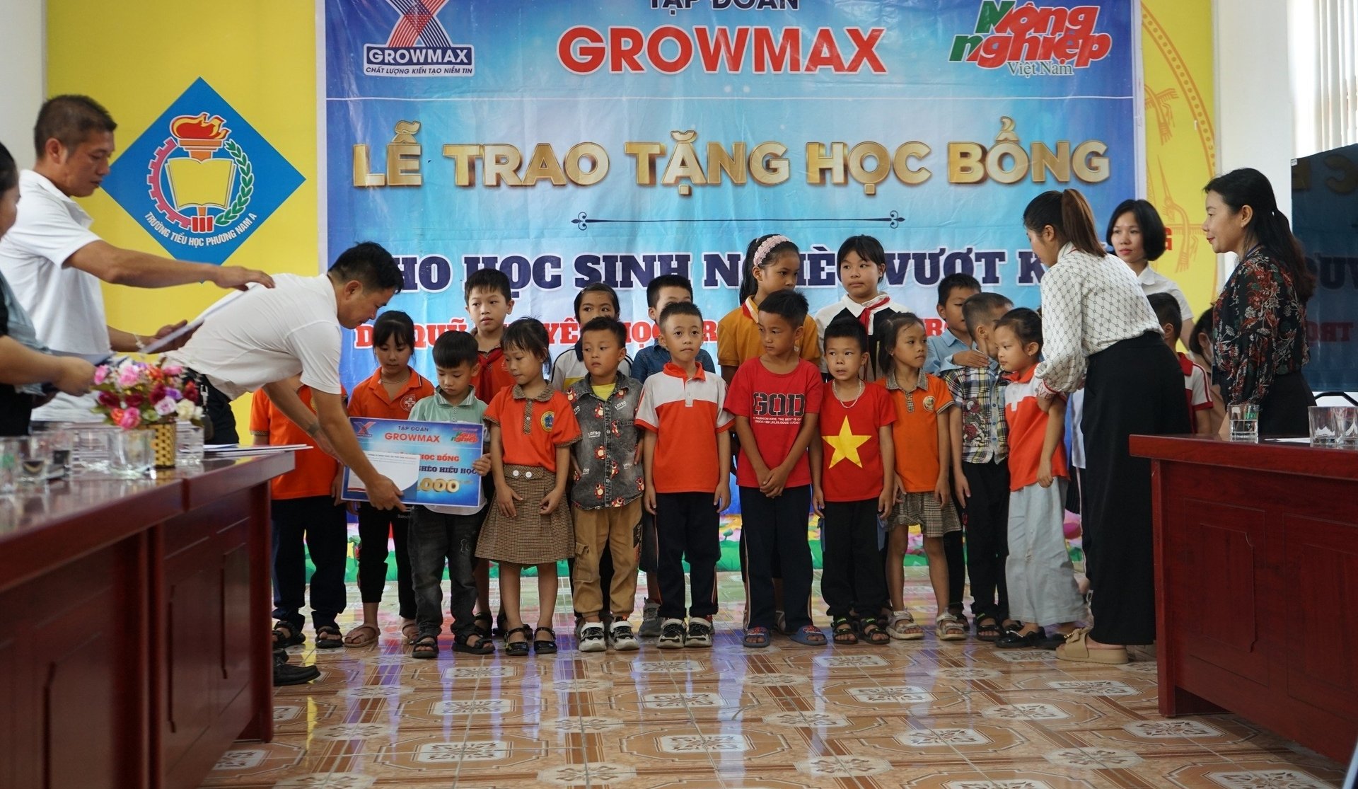 Đại diện Công ty GrowMax khu vực Miền Bắc trao phần quà cho các em học sinh nghèo vượt khó trường Tiểu học Phương Nam A.