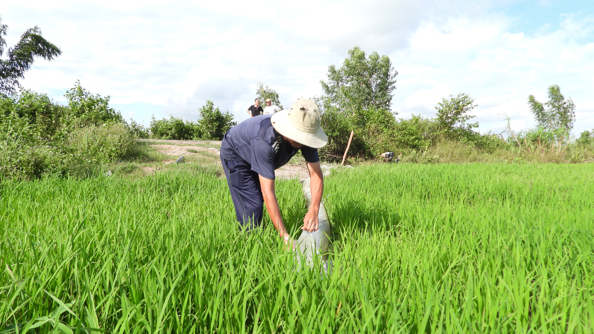 Người dân cạnh kênh Tây tranh thủ lấy nước để phục vụ sản xuất. Ảnh: Trần Trung.