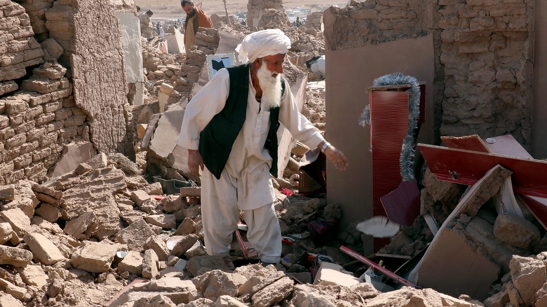 Một người đàn ông về lại nhà của mình sau trận động đất ở huyện Zendeh Jan, tỉnh Herat, Afghanistan hôm 8/10. Ảnh: AP.