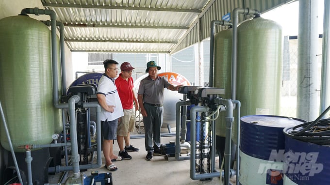 Ông Quyết (bìa phải) cùng các thành viên HTX Long Thành Phát đang kiểm tra hệ thống điện của toàn bộ hệ thống trang trại để không bị xảy ra sự cố bất ngờ. Ảnh: Lê Bình.