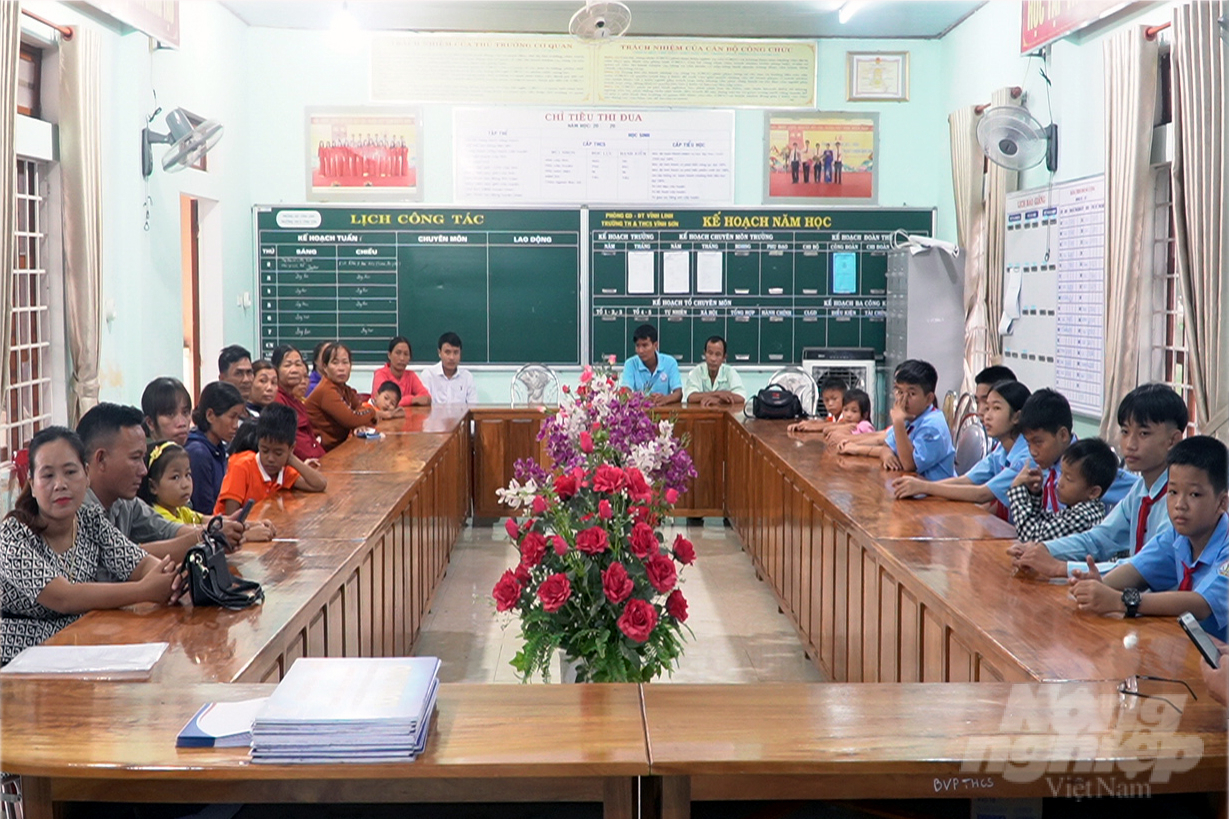 Phụ huynh và học sinh Trường THPT và THCS Vĩnh Sơn đội mưa đến trường nhận Quỹ khuyến học GrowMax. Ảnh: Võ Dũng.