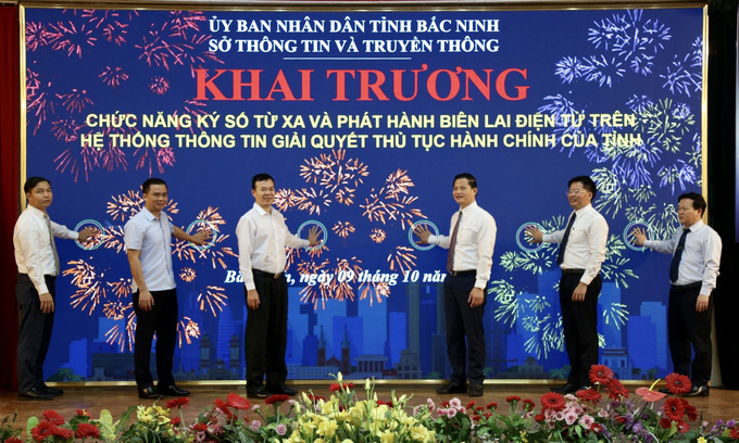 Các đại biểu thực hiện nghi thức nhấn nút khai trương chức năng ký số từ xa và phát hành biên lai điện tử trên hệ thống thông tin giải quyết thủ tục hành chính tỉnh Bắc Ninh.