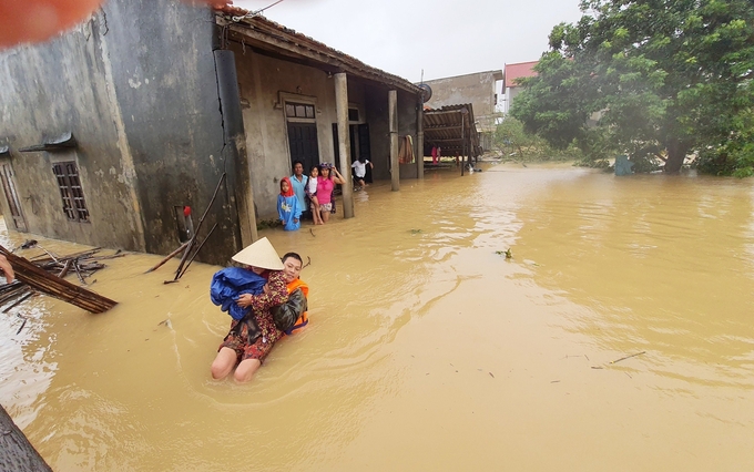 Thực hiện di dời người dân vùng thấp đến nơi an toàn trong bão lũ ở Quảng Bình. Ảnh: T.P.