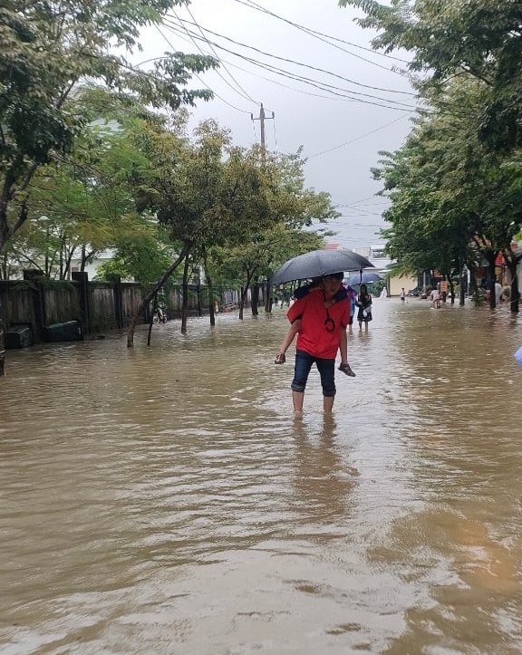 Một phụ huynh đón học sinh sớm sau khi nhà trường thông báo nghỉ học để ứng phó với mưa lớn kèo dài. 