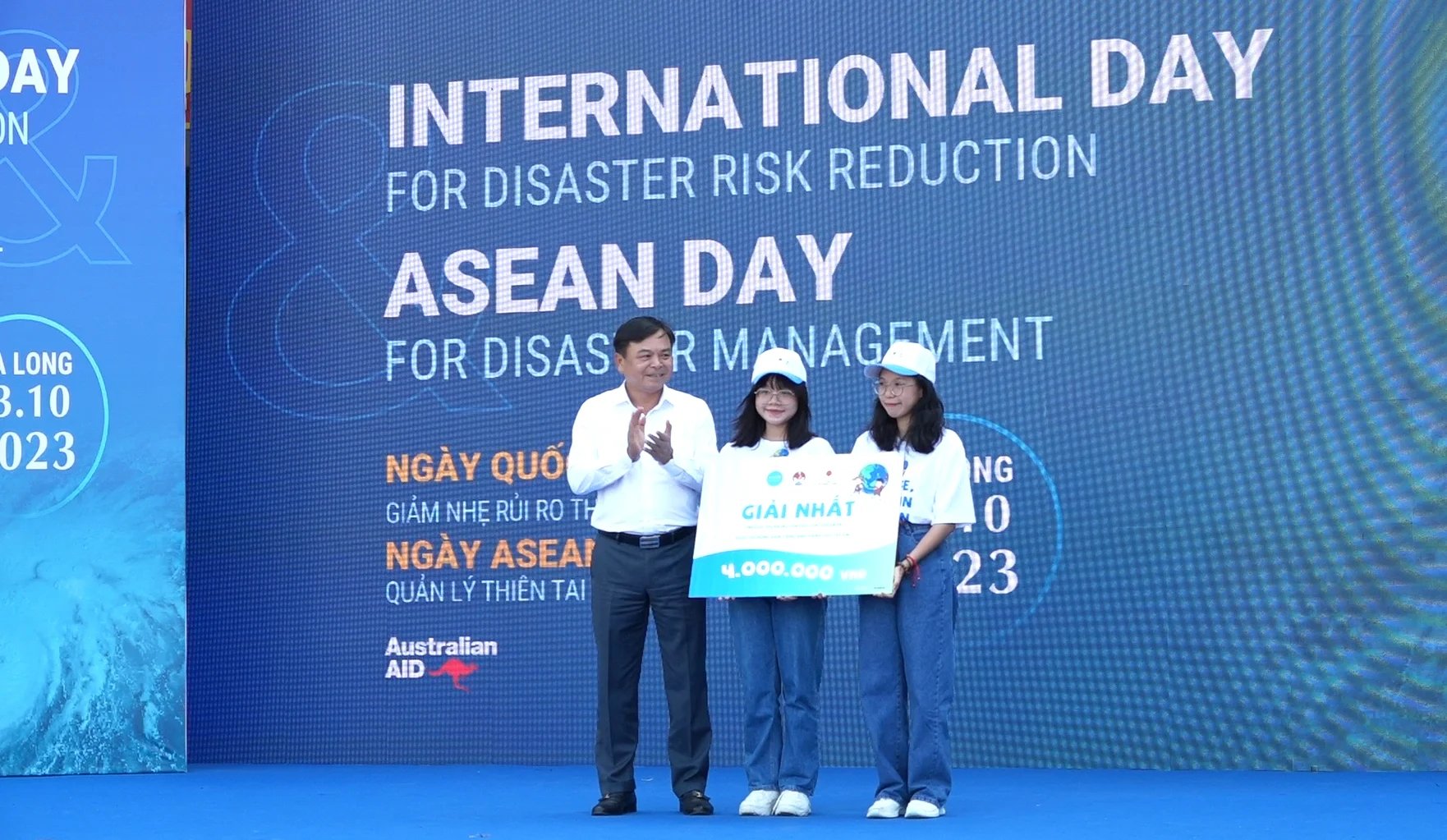 MARD Deputy Minister Nguyen Hoang Hiep awards the prize of the 'The English Speaking Contest on disaster risk reduction and climate actions' to two students, Tran Dang Thanh Phuong and Le Minh Thu. Photo: Nguyen Thanh.