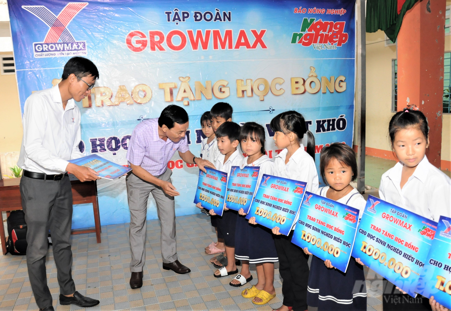 Thầy Nguyễn Kim Điền, Hiệu trưởng Trường Tiểu học Vĩnh Bình Bắc 4 cùng đồng hành trao các suất học bổng GrowMax cho các em học sinh nghèo, có hoàn cảnh khó khăn. Ảnh: Trung Chánh.