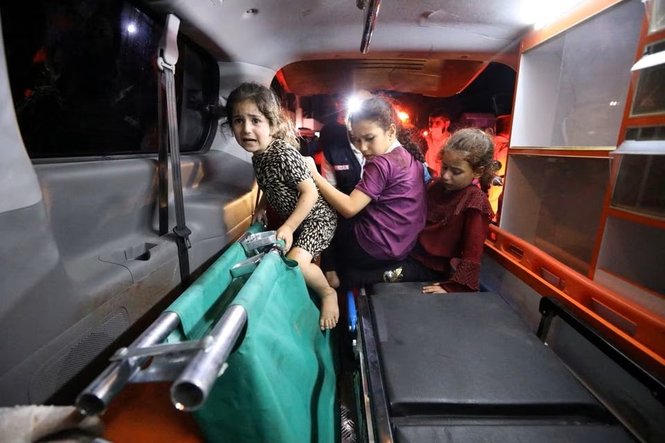 Trẻ em được di chuyển từ bệnh viện Al-Ahli đến bệnh viện Shifa bằng xe cứu thương. Ảnh: Reuters.
