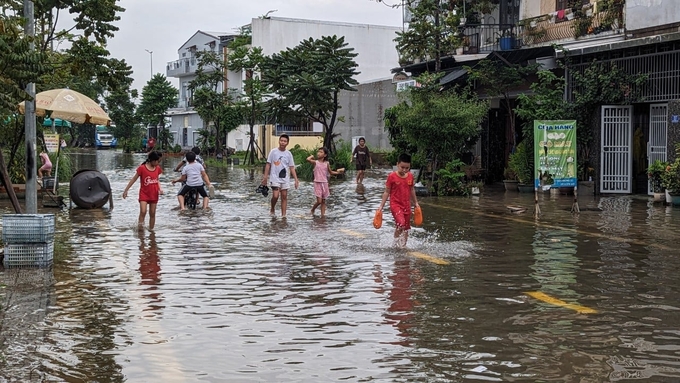Người dân di chuyển trên những tuyến phố ngập lụt ở khu quy hoạch Bắc Hương Sơ, thành phố Huế.