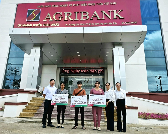 Đại diện Bảo hiểm Agribank Cần Thơ và Agribank huyện Tháp Mười chi trả quyền lợi bảo hiểm Bảo an tín dụng cho khách hàng. Ảnh: Lê Hoàng Vũ.