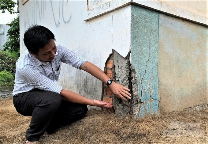 Anh Đoàn Hải Ngư, nhân viên quản lý, vận hành cống Ông Hiếu chỉ những vết rạn nứt, bê tông rơi rớt từng mảng, lộ ra những thanh thép đã hoen rỉ của nhà quản lý. Ảnh: Hồ Thảo.