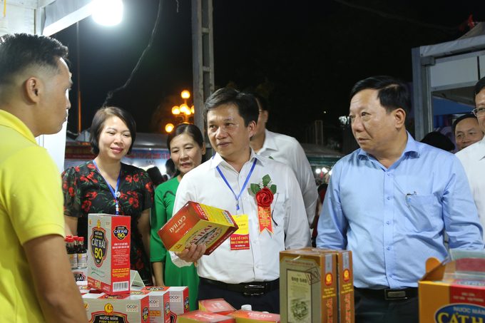 Ông Nguyễn Đức Thọ - Phó Chủ tịch UBND TP Hải Phòng (phải) và ông Lê Minh Lịnh - Phó Giám đốc Trung tâm Khuyến nông Quốc gia (giữa) cùng các đại biểu tham quan các gian hàng trưng bày sản phẩm OCOP tại hội chợ. Ảnh: Đinh Mười.