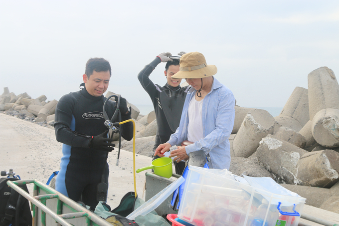 Các nhà nghiên cứu chuẩn bị dụng cụ lặn biển ở Bạch Long Vỹ đế điều tra nguồn lợi hải sản. Ảnh: Đinh Mười.