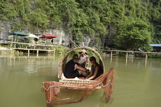 Du khách nước ngoài trải nghiệm chèo thuyền đánh bắt cá tại Ninh Bình. Ảnh: HV