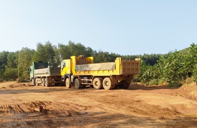 Xe tải vào chở đất trong các mỏ bên cạnh đầm Húng.