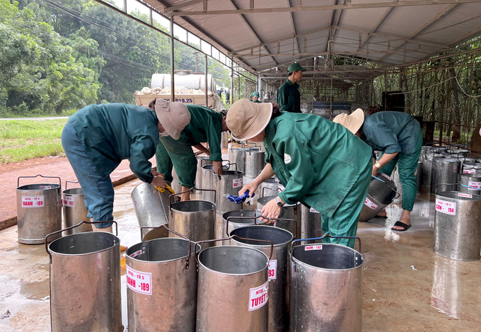 Công nhân Cao su Bình Long tráng rửa dụng cụ tại trạm giao nhận mủ, toàn bộ nước tráng rửa được xử lý sơ bộ và tưới cho vườn cao su. Ảnh: Thanh Sơn.