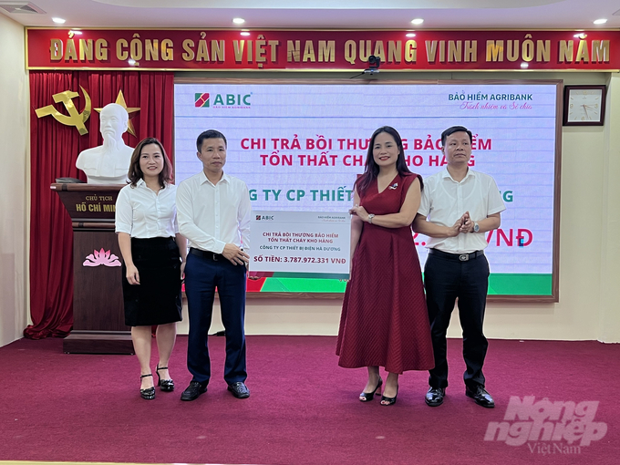 Lãnh đạo Bảo hiểm Agribank Thanh Hóa chi trả bồi thường tiền bảo hiểm tổn thất cho khách hàng. Ảnh: Quốc Toản.