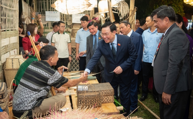 National Assembly Chairman Vuong Dinh Hue visited booths at the Craft Village Festival. Photo: NA.