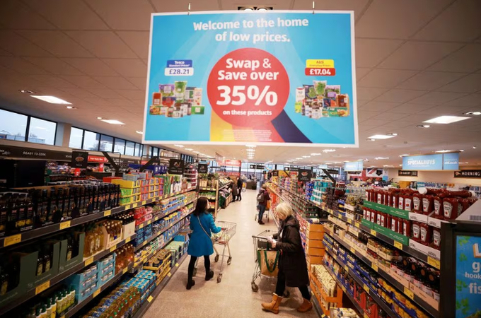 Shoppers push trolleys along an aisle inside an ALDI supermarket near Altrincham, Britain, February 20, 2023. REUTERS/Phil Noble/File Photo Acquire Licensing Rights.