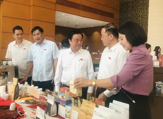 Bộ trưởng Bộ NN - PTNT Lê Minh Hoan (đứng giữa) cùng các đại biểu Quốc hội tỉnh Sơn La tham quan sản phẩm Cà phê Sơn La. Ảnh: sonla.gov.vn.