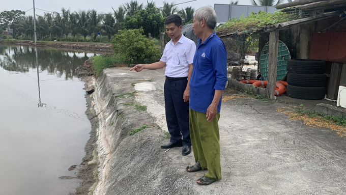 Ông Phạm Huy Trung, cán bộ Chi cục Thủy sản Ninh Bình (bên trái) trao đổi với hộ nuôi trồng thủy sản trên địa bàn huyện Kim Sơn. Ảnh: Huy Bình. 