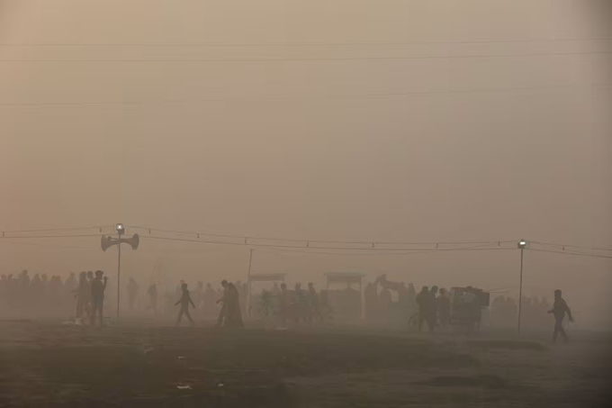 Các tín đồ đạo Hindu rời đi trong làn khói bụi ô nhiễm sau khi dự lễ hội Chhath Puja ở New Delhi, Ấn Độ, hôm 20/11. Ảnh: Reuters.