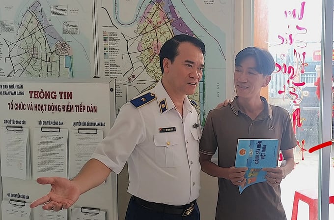 Thiếu tướng Vũ Trung Kiên trò chuyện với ngư dân thị trấn Vàm Láng. Ảnh: Minh Đảm.