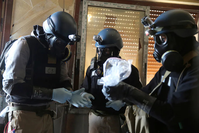 Nhóm chuyên gia vũ khí hóa học của Liên hợp quốc đeo mặt nạ phòng độc thu thập mẫu vật. Ảnh: Reuters.