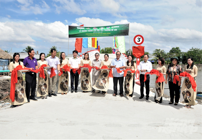 Đại diện nhà tài trợ Công ty CP Nhựa Thiếu niên Tiền Phong, Nhóm từ thiện Từ Tâm và lãnh đạo địa phương cắt băng khánh thành 'Cầu nối yêu thương' số 104, bắc qua Kênh Thứ 9, xã Thuận Hòa, huyện An Minh. Ảnh: Trung Chánh.