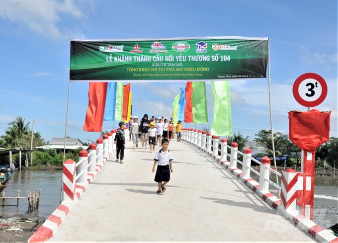 'Cầu nối yêu thương' số 104 bắc qua kênh Thứ Chín, tạo điều kiện cho hàng trăm hộ dân xã Thuận Hòa đi lại thuận tiện, lưu thông hàng hóa và các em học sinh đến trường an toàn. Ảnh: Trung Chánh. 