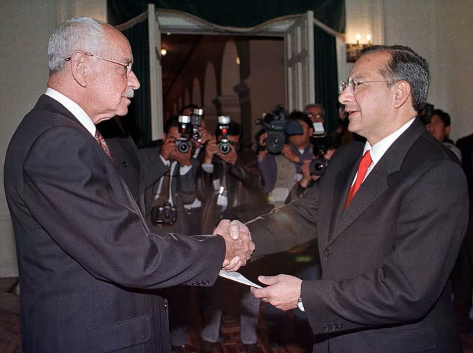 Cố Tổng thống Bolivia Hugo Banzer (bên trái) bắt tay Victor Manuel Rocha (bên phải), Đại sứ Mỹ tại Bolivia khi đó, trong một buổi lễ tại Phủ Tổng thống ở La Paz hồi tháng 8/2000. Ảnh: Reuters.