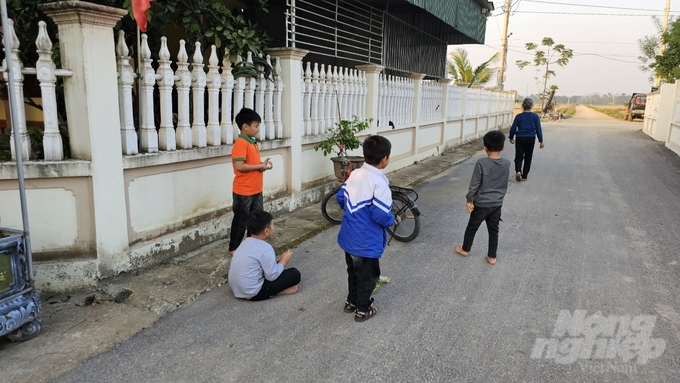 Lũ trẻ trong làng tùm năm tụm bảy nô đùa đùa trên con đường làng thẳng tắp sau mỗi giờ tan trường. Ảnh: Quốc Toản.