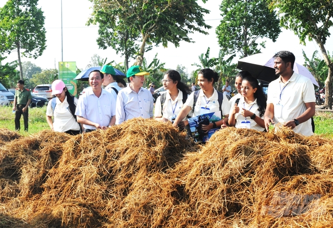 Các đại biểu quốc tế tham quan mô hình xử lý rơm rạ thành phân bón hữu cơ, tạo chuỗi kinh tế tuần hoàn trong sản xuất lúa. Ảnh: Trung Chánh.