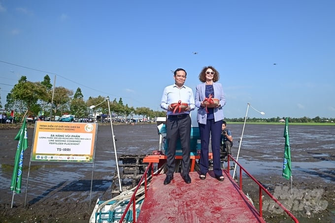 Phó Thủ tướng Trần Lưu Quang và Giám đốc Quốc gia Ngân hàng Thế giới (WB) tại Việt Nam thực hiện nghi thức đưa hạt giống vào máy trình diễn gieo sạ.
