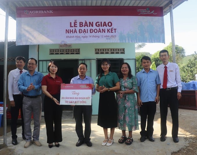 Lãnh đạo Agribank Chi nhánh tỉnh Khánh Hòa trao biểu trưng tài trợ 1,8 tỷ đồng xây dựng 30 căn nhà đại đoàn kết tại huyện Khánh Vĩnh. Ảnh: PV.