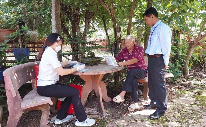 Lực lượng cán bộ thú y tỉnh Bình Phước tuyên truyền vận động người dân ký cam kết không thả chó chạy rông. Ảnh: Thanh Sơn.