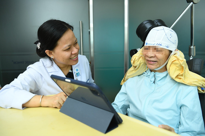BS.CKII Tống Mai Trang trò chuyện cùng người bệnh đang điều trị sa sút trí tuệ bằng phương pháp kích thích não sâu. Ảnh: BVCC.