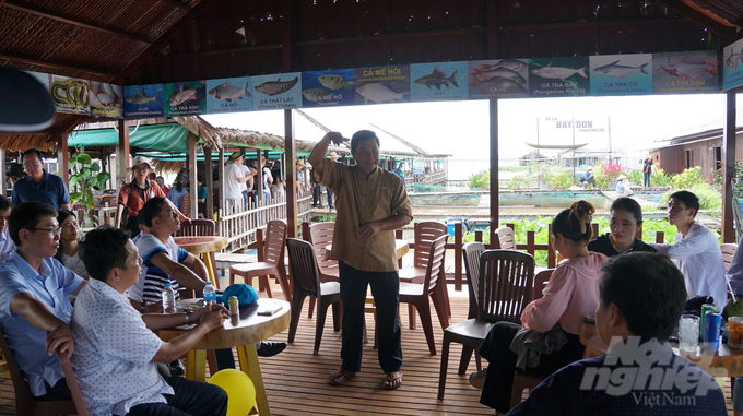 Lão nông Lý Văn Bon giới thiệu về cách chăm sóc cá với đoàn tham quan của Ban Quản lý An toàn thực phẩm TP.HCM. Ảnh: Nguyễn Thủy.