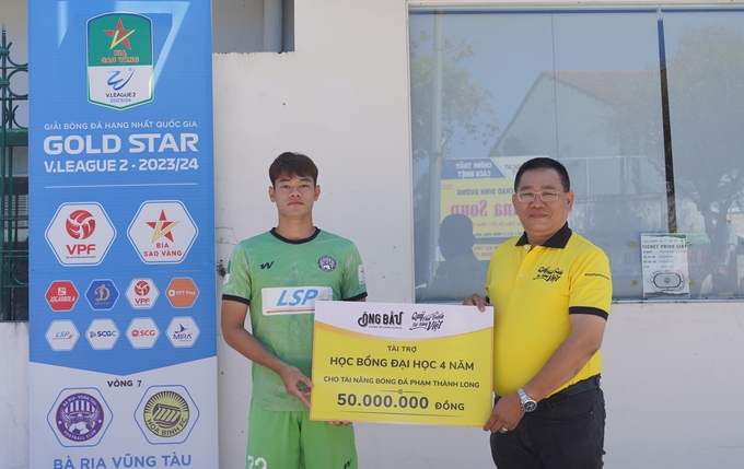 Tài năng bóng đá Phạm Thành Long nhận bảng tượng trưng học bổng từ đại diện Quỹ Phát triển Tài năng Việt.