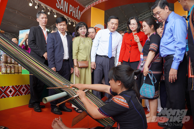 Đại biểu xem nghệ nhân dệt thổ cẩm tại gian hàng trưng bày của tỉnh Gia Lai. Ảnh: Nguyễn Thủy.