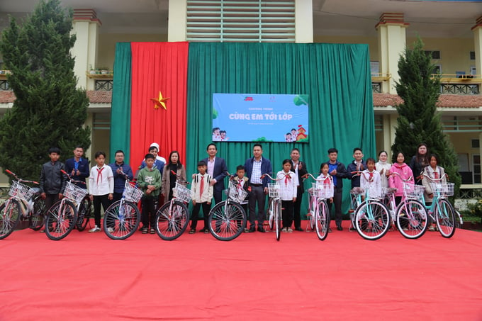 Lãnh đạo Báo Nông nghiệp Việt Nam, Công ty Cổ phần Cao su Lai Châu 2 cùng các thầy cô trao tặng xe đạp cho học sinh khó khăn tại Trường THCS Chăn Nưa. Ảnh: H.Đ.