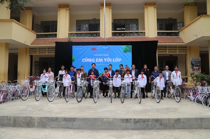 Lãnh đạo Báo Nông nghiệp Việt Nam, Công ty Cổ phần Cao su Lai Châu 2 cùng các thầy cô trao tặng xe đạp cho học sinh khó khăn tại Trường THCS Nậm Pỳ. Ảnh: H.Đ.