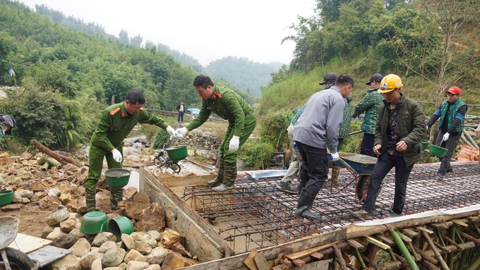 Cán bộ công an cùng bà con nhân dân xã Hoàng Liên xây cầu dân sinh giúp việc đi lại bớt khó khăn hơn. Ảnh: T.L.