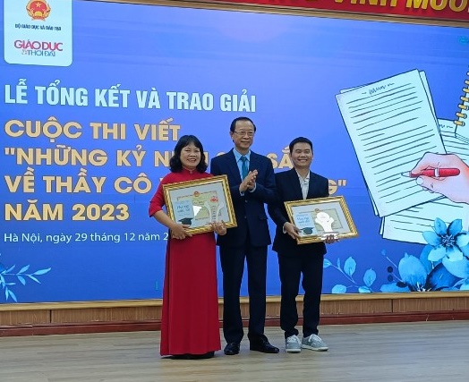 Ông Phạm Ngọc Thưởng - Thứ trưởng Bộ GD-ĐT trao giải cho các tác giả Nguyễn Thị Hiền và Cao Văn Dũng có tác phẩm đoạt giải Nhất.