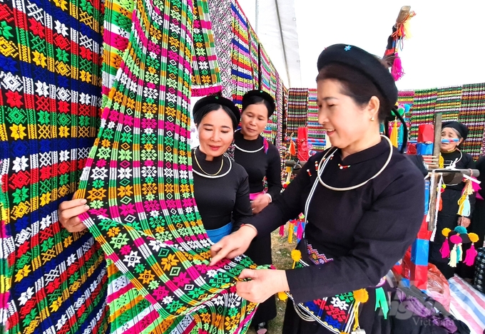 Chị Ngô Thị Phin (ngoài cùng bên phải) hướng dẫn các thành viên trong Tổ thêu dệt thổ cẩm các đường hoa văn tinh xảo. Ảnh: Đào Thanh.