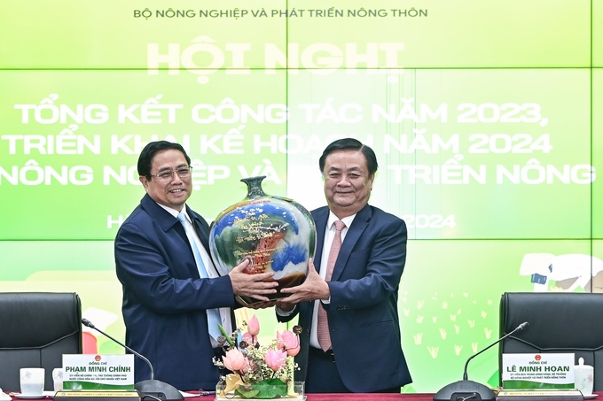 Bộ trưởng Lê Minh Hoan đại diện Bộ NN-PTNT tặng Thủ tướng Phạm Minh Chính bình gốm với thông điệp 'Chạm để kết nối'. Ảnh: Tùng Đinh.