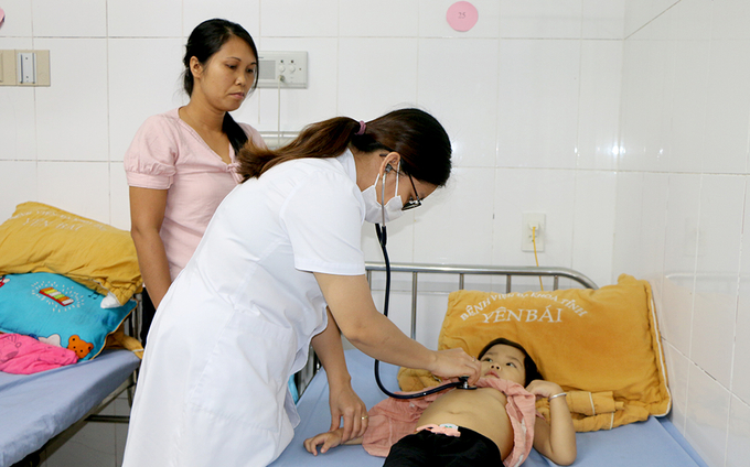 Cán bộ Y tế Bệnh viện đa khoa tỉnh Yên Bái khám bệnh cho một trường hợp bệnh nhi mắc cúm mùa.