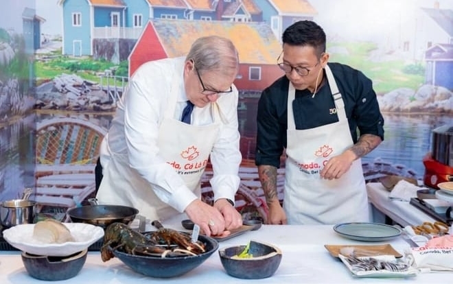 Bộ trưởng Bộ Nông nghiệp và Nông sản Thực phẩm Canada Lawrence MacAulay đích thân chế biến món tôm hùm nổi tiếng của Canada trong một sự kiện quảng bá hình ảnh đất nước này. Ảnh: Vietnam+